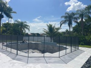 Removable mesh pool safety fence installed around a backyard pool in Pembroke Pines, Florida