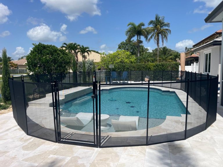 Black mesh pool fence and gate beside a shallow sun shelf in Pembroke Pines, an example for fence reinstallation planning