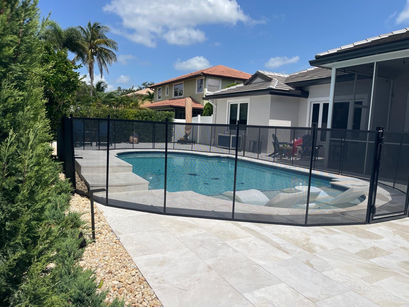 Side view of black mesh pool fencing and pool deck in Pembroke Pines
