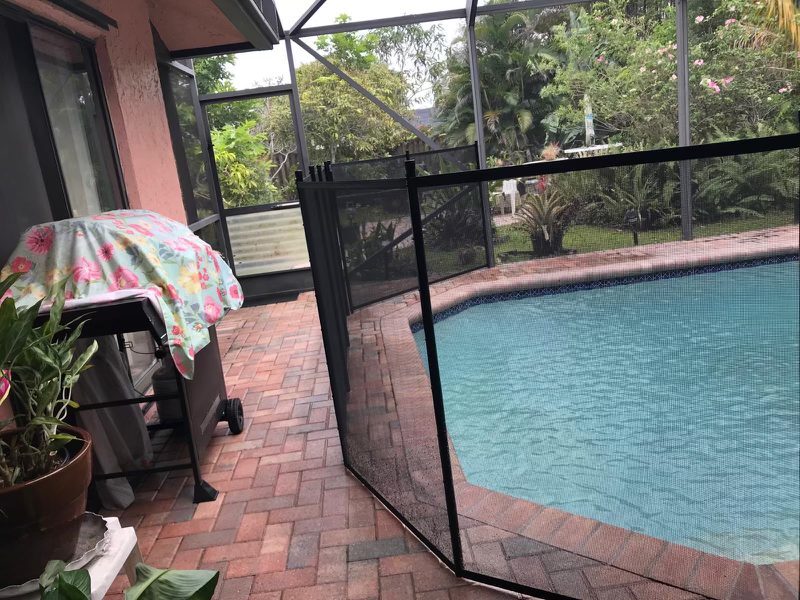 Pool fence and gate beside the house and outer screen-enclosure door