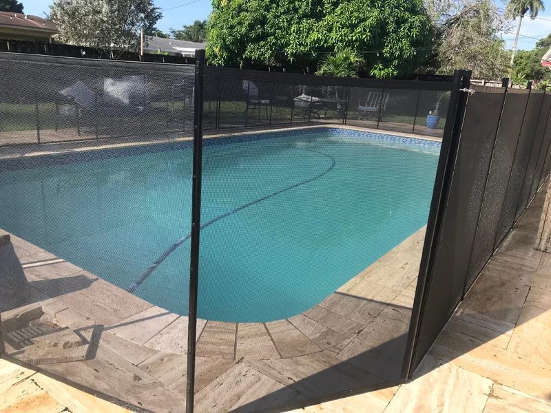 Mesh pool fence posts following a change of direction beside the pool