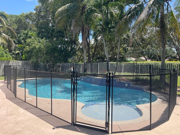 Black mesh fence and front gate around a Weston pool with a raised tiled spa